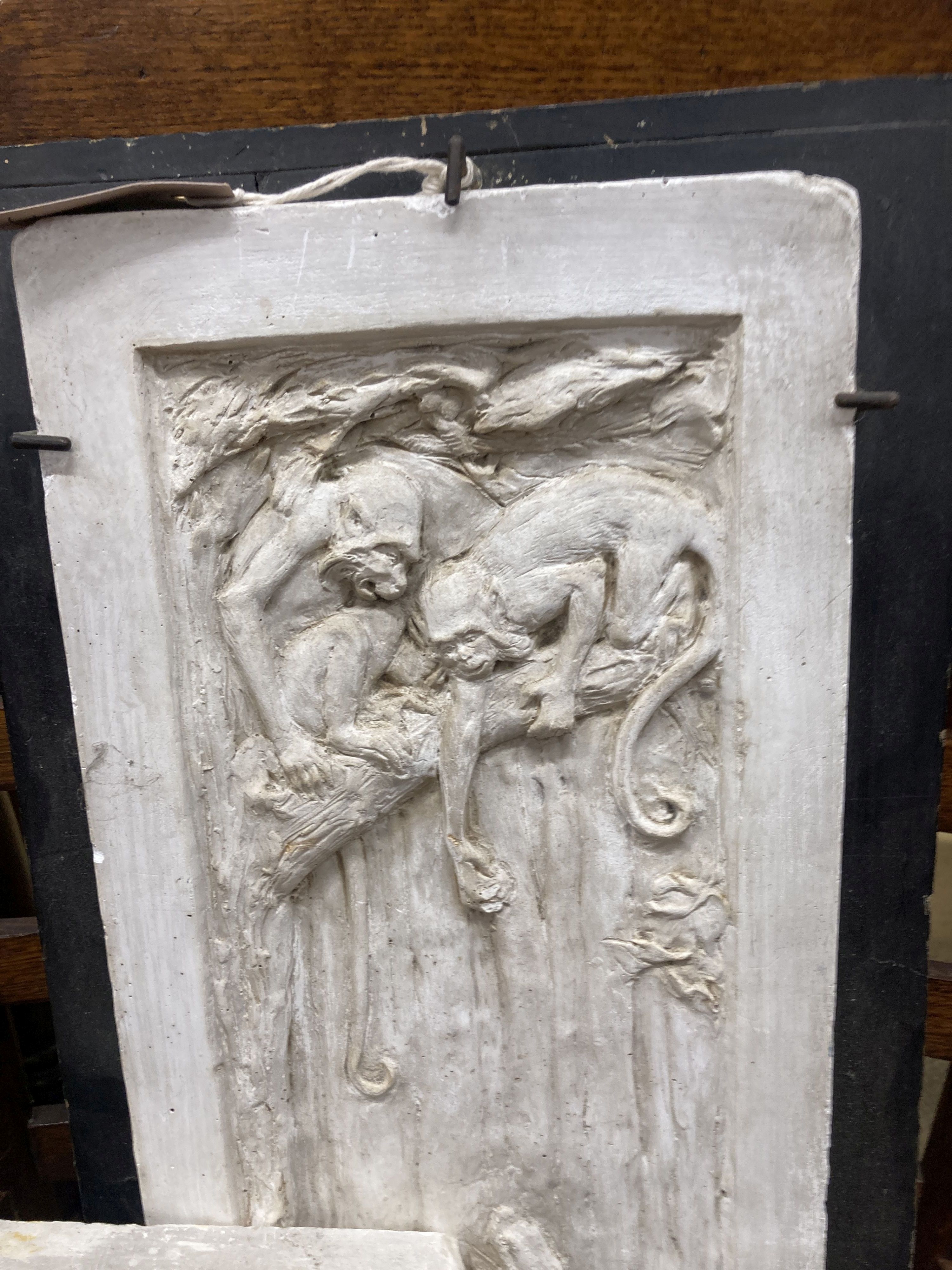 A pair of rectangular cast plaster plaques, larger 59cm high, 22cm wide together with a Victorian style cast iron doorstop